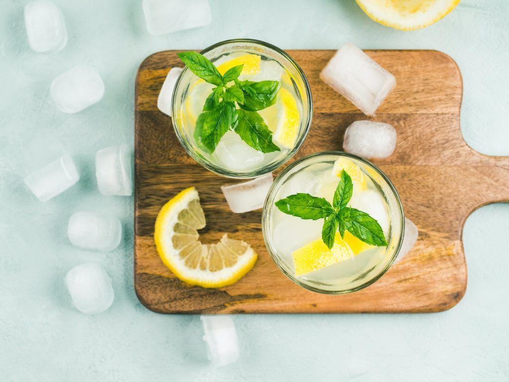 Fresh lemon lemonade in jug and glasses